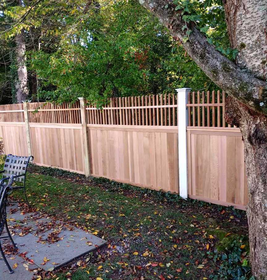 Wood fence with vertical panels and open picket top